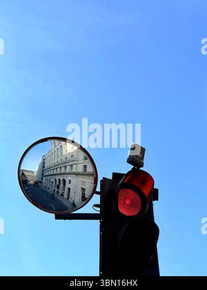 Traffic lights on red with mirror showing empty street in the  City of London Stock Photo