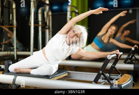 Elderly woman doing side bends Stock Photo