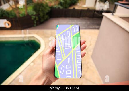 Woman looking at city map on her mobile phone outdoors, closeup Stock Photo