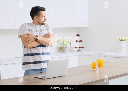 Young man having panic attack in kitchen Stock Photo