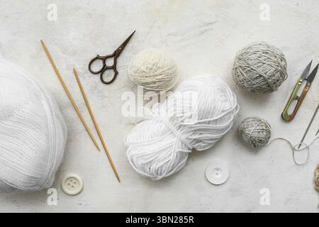 Knitting needles, yarn balls and scissors on white background Stock Photo
