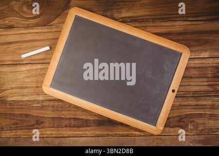 flat design art is showing diagonal framed blackboard on rustic wooden table with white chalk Stock Photo