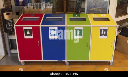 Aarhus, Denmark - November 16, 2022: Seperating waste in different colorful waste bins with Danish text for plastic packaging, food, paper and carton Stock Photo