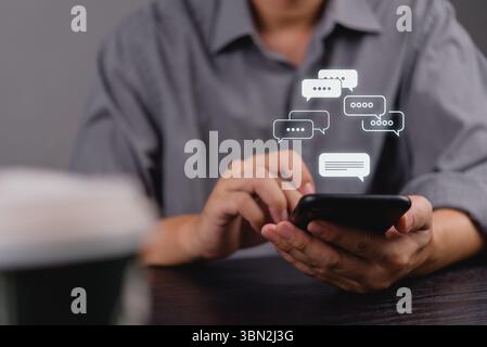 Hand holding smartphone with chat bubbles overlay. Digital network Social media online communication, instant messaging and online interaction concept Stock Photo