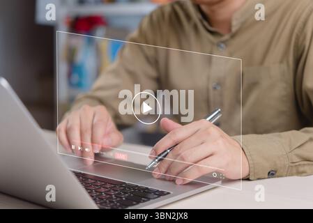 Businessman watching and interacting with live streaming video on laptop. Ideal for online education, live broadcasts, digital communication, and remo Stock Photo
