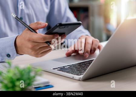 business professional planning and managing tasks with a laptop and smartphone, symbolizing teamwork, entrepreneurship, and business growth. Stock Photo