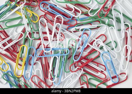 Multicolored paper clips on a white background, texture background Stock Photo