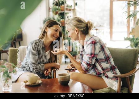Two women are having a trust conversation while sitting in a restaurant Stock Photo