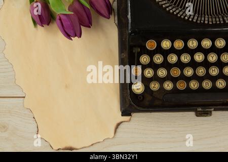 Typewriter and flowers on table Stock Photo