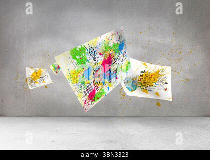 Sheets with graphics and splashes over grey wall Stock Photo