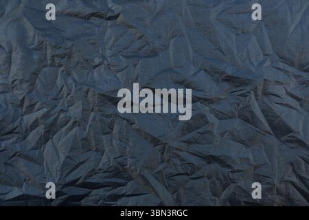 it is wrinkled black silk fabric texture for background and design. Stock Photo