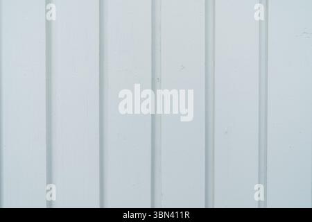 Simple background of white painted wooden planks. Minimalist texture of a wall or facade with vertical parallel lines. Stock Photo
