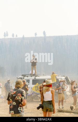 Bearded man leading a gathering during festival, standing on van roof Stock Photo