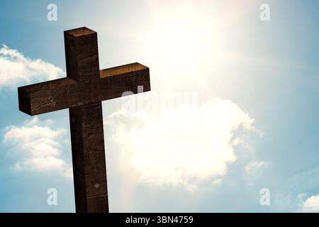 Wooden cross is standing in flat design composition, with sun shining through clouds and lens flare Stock Photo