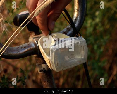 Close-up of a hand switching on an old vintage bicycle light Stock Photo