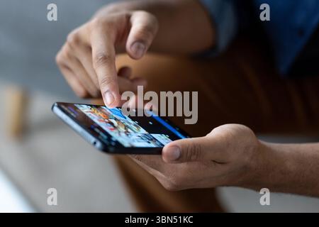 A person uses a smartphone, touching the screen with a finger. Focus is on the hand and device, suggesting interaction and connectivity. Stock Photo