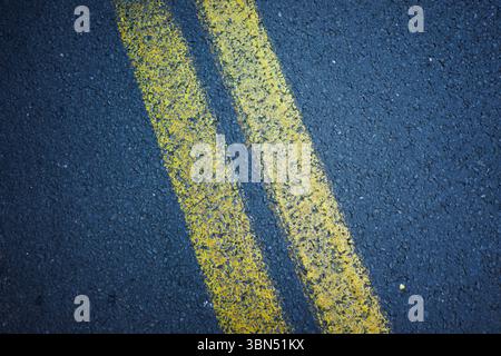 Yellow stripes on the asphalt, road markings, abstract composition. Stock Photo