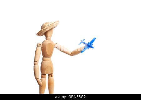 A wooden toy mannequin with a straw hat holding a blue plastic toy plane on a white background Stock Photo