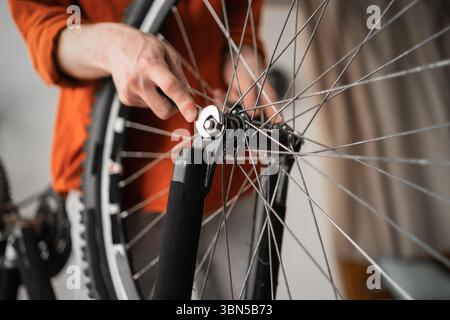 Part of bicycle. Close-up of male hands fixing bike Wheel. Bike maintenance Stock Photo