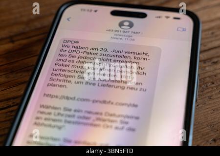 Phishing-SMS auf Smartphone mit DPD-Betrugsversuch 30.06.25, Selters: Symbolfoto, Illustrationsbild, Symbolbild, Illustrationsfoto, Alltagsszene Eine betrügerische SMS auf einem Smartphone-Display warnt angeblich vor einem nicht zustellbaren Paket von DPD und enthält einen verdächtigen Link. Die Nachricht wurde am 30. Juni 2025 empfangen und ist ein typisches Beispiel für Phishing-Versuche über Kurznachrichten. Die Aufnahme zeigt das Smartphone auf einem Holztisch liegend. Solche Betrugsversuche nehmen zu und zielen darauf ab, persönliche Daten durch gefälschte Webseiten zu stehlen. Selters He Stock Photo
