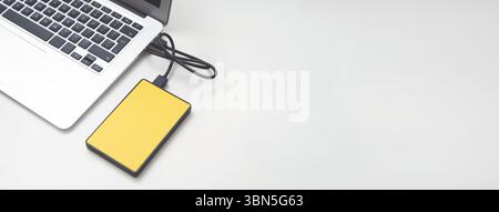 External backup disk hard drive connected to laptop. hard drive backup disk external computer data usb concept Stock Photo
