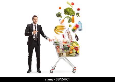 Businessman pointing at falling food in a shopping cart isolated on white background Stock Photo