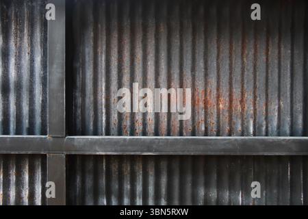 black rusty galvanized iron background with iron rack. Stock Photo