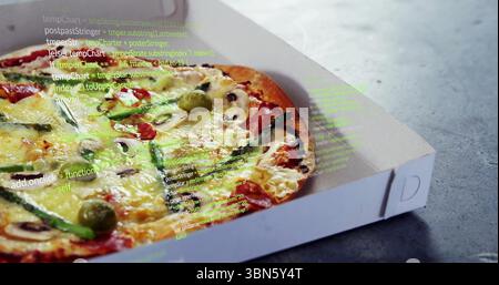 Displaying pizza in white box on grey tabletop with vegetable toppings and code overlay, copy space Stock Photo