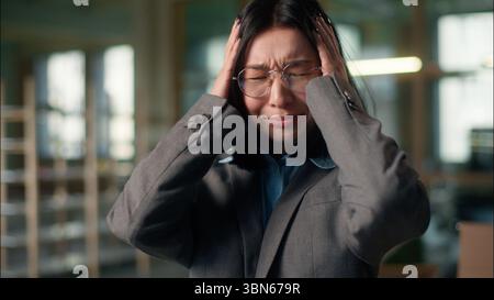 Stress work problem annoyed Asian Chinese Korean business woman holding head pain headache overworked sorrow emotion Japanese girl businesswoman Stock Photo