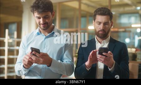 Busy men colleagues businessmen business partners Caucasian guys co-workers managers entrepreneurs usage mobile phones gadgets addict male employees Stock Photo