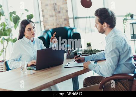 Professional Discussion Between Two Coworkers in a Stylish Office Setting Showcasing Collaboration and Teamwork Stock Photo