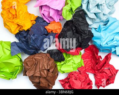 A vibrant collection of crumpled papers in various colors is scattered across a white background. Stock Photo