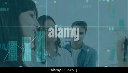 Brainstorming three colleagues writing on sticky note covered whiteboard in meeting room Stock Photo