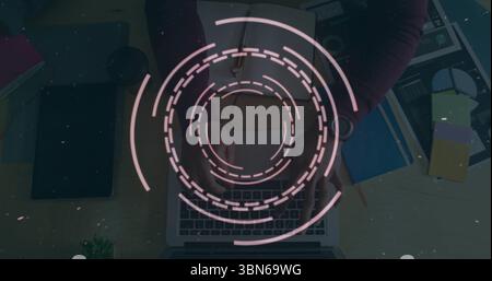 Circular digital interface image over person typing on laptop at desk Stock Photo