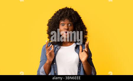 Amazed african american woman raising hands up Stock Photo