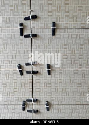 Tile leveling clips and spacers installed on wall tiles during a bathroom renovation. Stock Photo