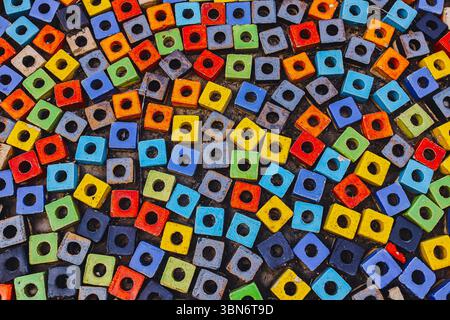 Close-up of walkway paved with colorful hollow square beads, mosaic pattern background showing urban creativity and diversity. Stock Photo