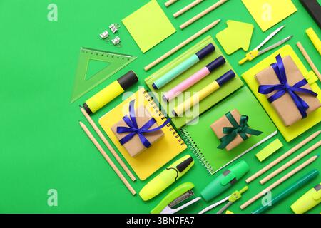 Gift boxes with different stationery on green background Stock Photo