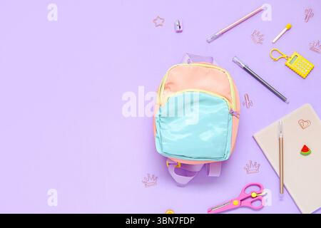 Color school backpack with different stationery on lilac background Stock Photo