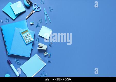 Notebooks and different stationery on blue background Stock Photo