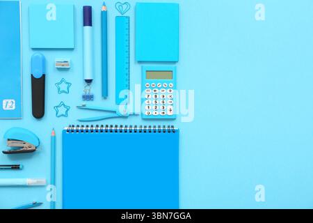 Composition with notebooks and different stationery on blue background Stock Photo