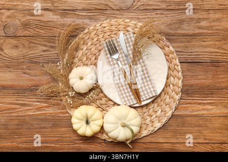 Beautiful table setting with fresh pumpkins and gypsophila flowers on wooden background Stock Photo