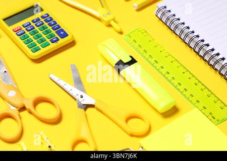 Composition with calculator and different school stationery on yellow background, closeup Stock Photo