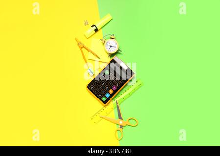 Composition with alarm clock, calculator and different school stationery on color background Stock Photo