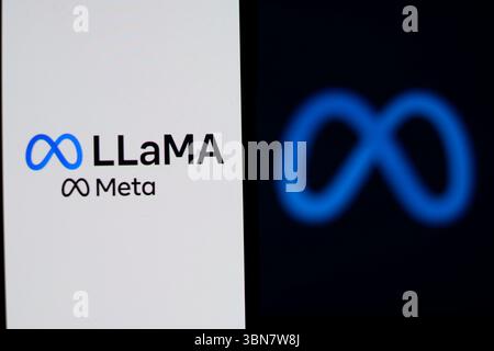 LLaMA Meta AI logo is displayed on a mobile phone screen with Meta logo in the background for illustration photo. Stock Photo