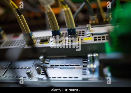 Flat design is showing LC fiber optic cables connecting into network patch panel chassis in rack Stock Photo