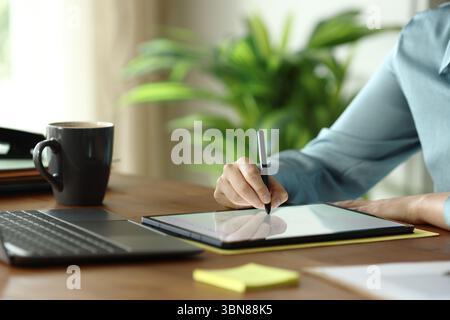 Close up of an office worker hands handwriting on tablet at office Stock Photo