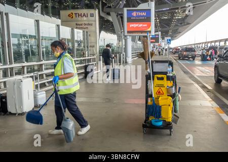Working female staff cleaning outside Suvarnabhumi Airport bangkok, Thailand Stock Photo