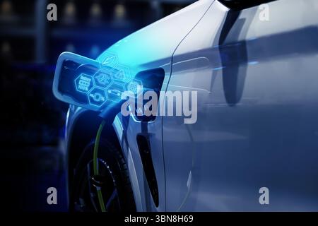 Power cable pump plug in charging power to electric vehicle EV car. Stock Photo