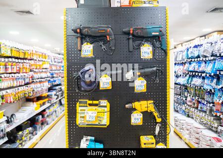 A hardware store display shows various power tools hanging on a pegboard. Mbk Center Bangkok, Thailand Stock Photo